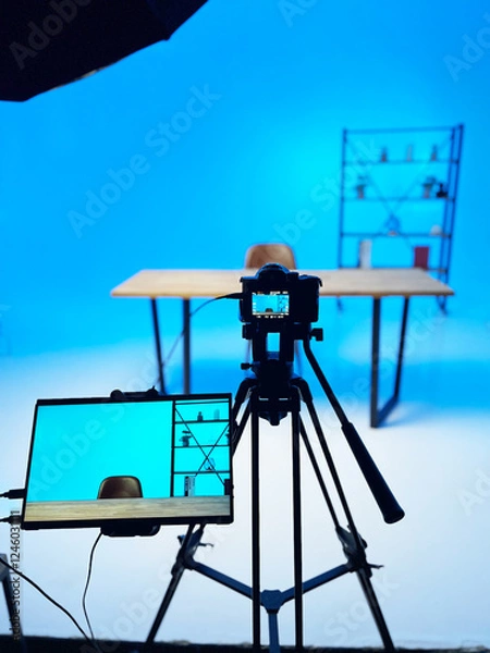 Fototapeta Podcast interview setup featuring a microphone and backdrop with a blue hue in a studio environment
