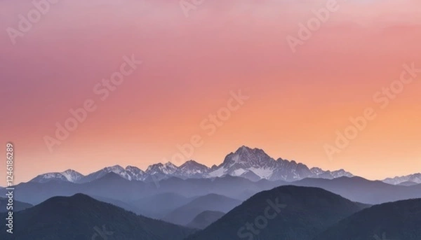 Fototapeta Sunrise over a serene mountain range with a soft orange and pink sky