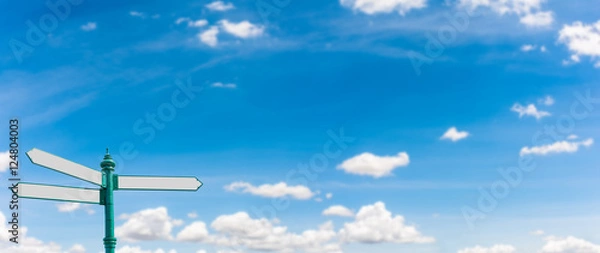 Fototapeta Three Direction Blank Road Sign on Blurry Blue Sky And White Clouds Panorama Background, Left Position