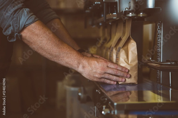 Obraz Nie do poznania mężczyzna ustawia torebki kawy w kolejce