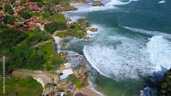 Obraz Aerial Drone view of the beach with white sand, coral rocks, hills with trees, waves from the ocean which is a tourist destination known as Mbuluk Beach Gunung Kidul Yogyakarta