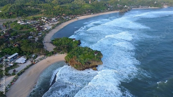Fototapeta Aerial Drone view of the beach with white sand, coral rocks, hills with trees, waves from the ocean which is a tourist destination known as Krakal Beach Gunung Kidul Yogyakarta