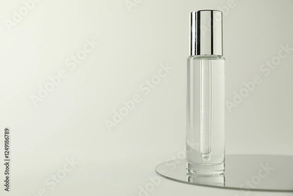 Fototapeta Bottle of serum and mirror on light background, space for text