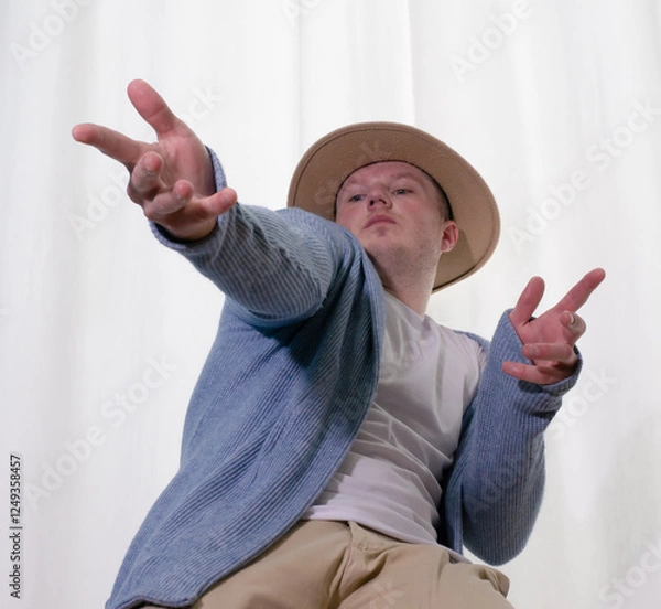 Obraz Young guy dancer in motion in a pose. A man performs a modern dance in casual clothes.