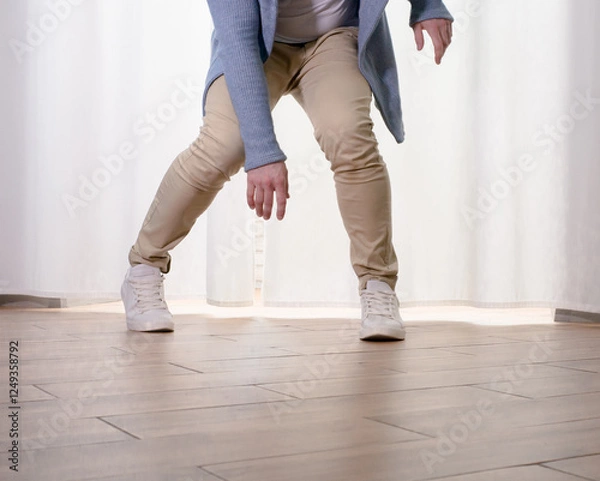 Obraz Young guy dancer in motion in a pose. A man performs a modern dance in casual clothes.