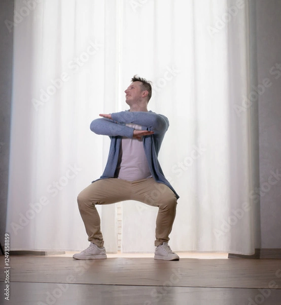 Obraz Young guy dancer in motion in a pose. A man performs a modern dance in casual clothes.