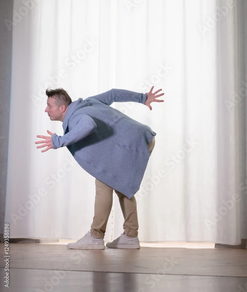 Obraz Young guy dancer in motion in a pose. A man performs a modern dance in casual clothes.