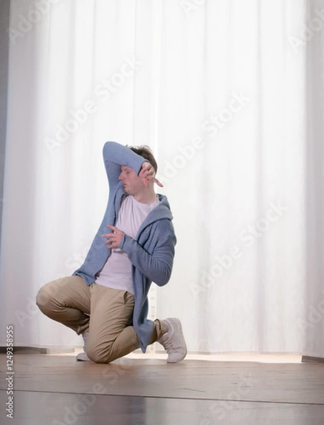 Obraz Young guy dancer in motion in a pose. A man performs a modern dance in casual clothes.