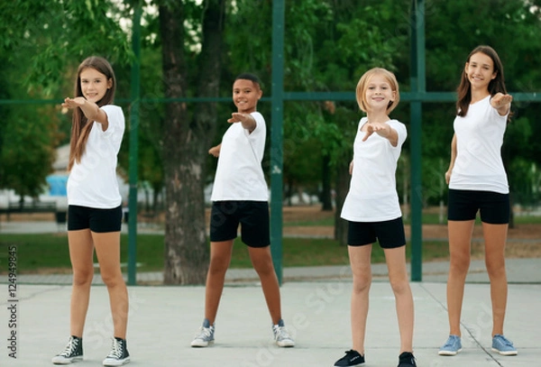 Fototapeta Students doing physical exercises on school yard
