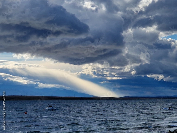 Obraz Dramatic storm clouds over the sea with sun rays breaking through