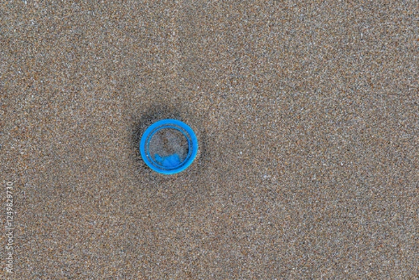 Obraz A blue object is sitting on a sandy beach