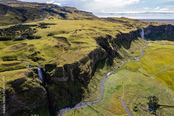 Obraz A aerial view Gljufrabui and Seljalandsfoss waterfall in Iceland plunges over the edge of green cliffs, surrounded by stunning countryside. The serene landscape captures beauty of untouched nature