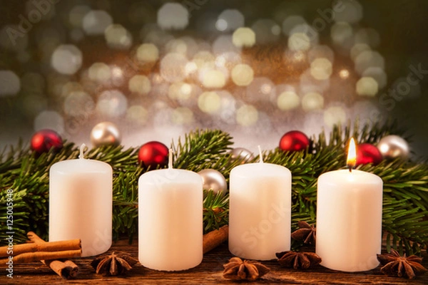 Fototapeta eine brennend Advent-Kerze vor Weihnachtsschmuck im Tannenzweig