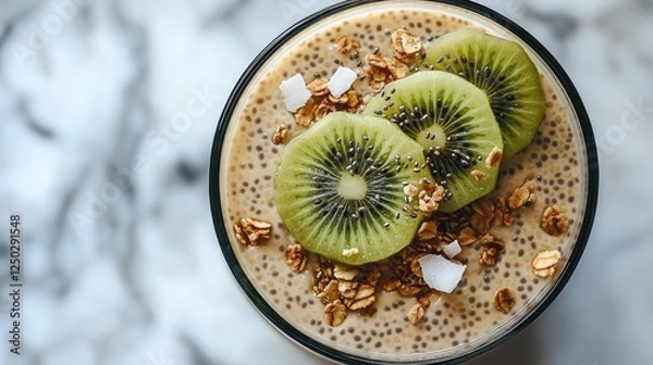 Fototapeta Healthy smoothie topped with kiwi slices and granola on a marble countertop background