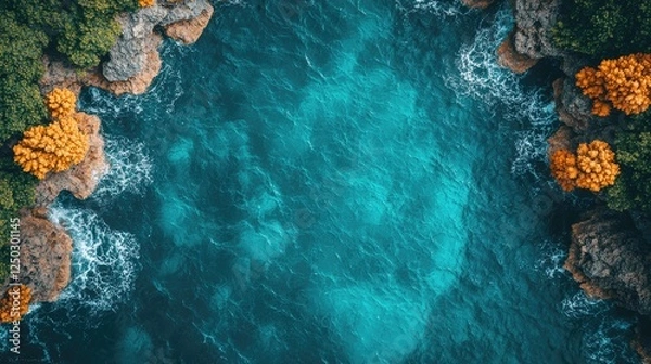 Obraz Aerial view of turquoise ocean waves crashing against rocky shores surrounded by lush greenery