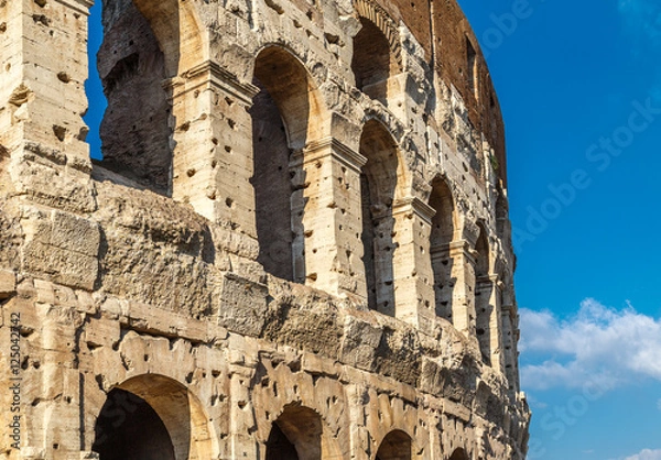 Fototapeta Colosseum, cultural and historical monument in Rome, a fragment of a wall with damages