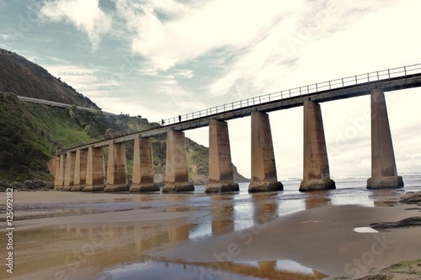 Obraz a heavy concrete train bridge crossing a river
