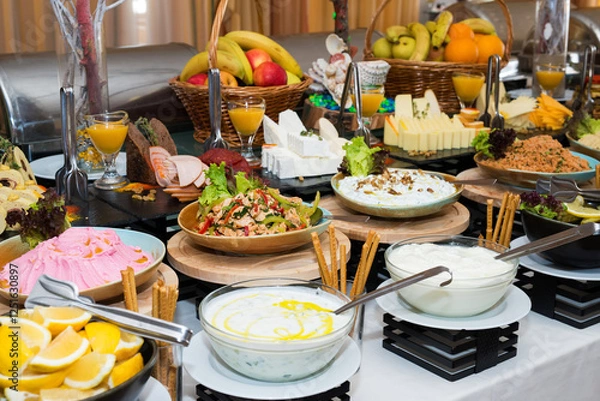 Fototapeta Snacks for the holiday, catering. Various snacks. Assortment of salads and buffet dishes. Meat, fish, cheese, salads, fruits and vegetables, sauces and canapes for celebrating a festive event.