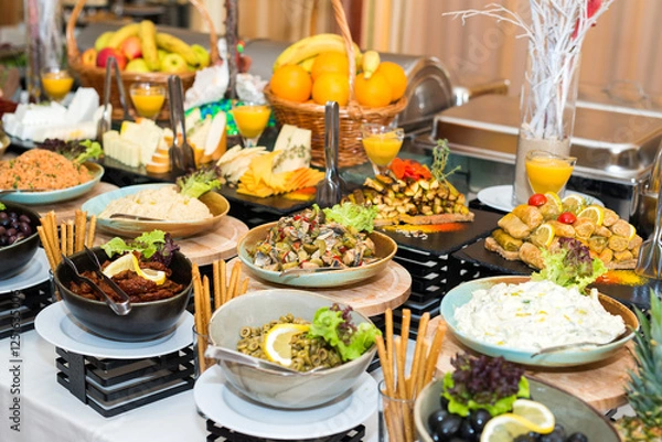 Fototapeta Snacks for the holiday, catering. Various snacks. Assortment of salads and buffet dishes. Meat, fish, cheese, salads, fruits and vegetables, sauces and canapes for celebrating a festive event.