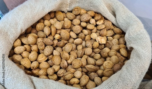 Obraz The ripened in-shell nuts are filled into large bags for sale at the city market