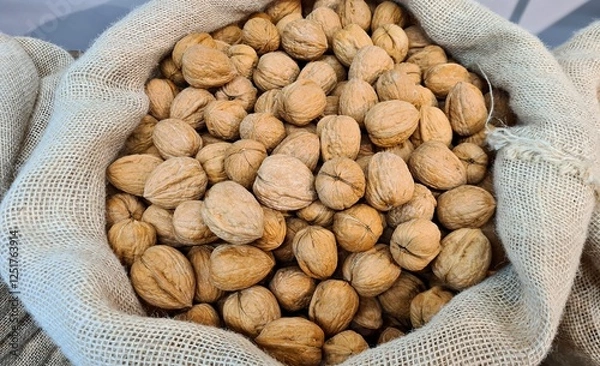 Obraz The ripened in-shell nuts are filled into large bags for sale at the city market