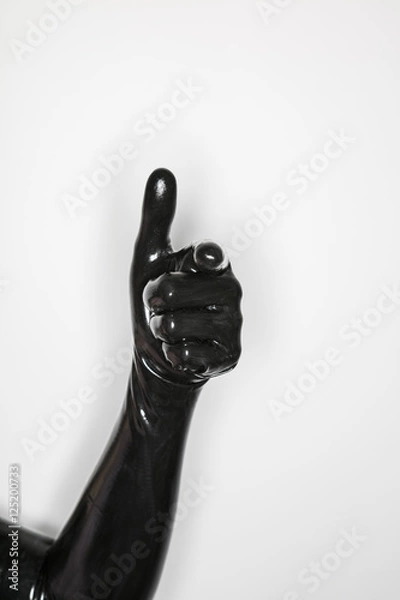 Fototapeta gesture of a hand wearing a black latex glove, thumb up
