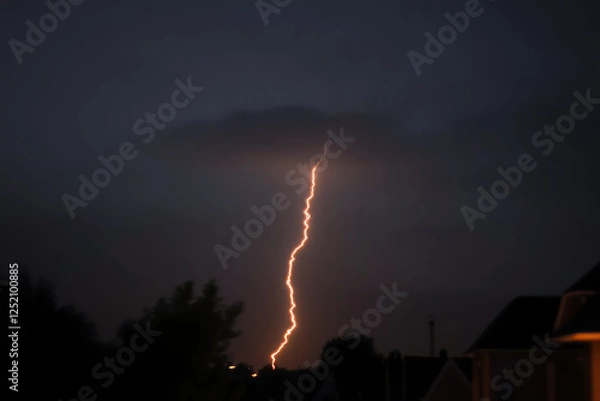 Fototapeta Dramatic lightning strike against a dark stormy sky with glowing orange light trails across the horizon, capturing raw power and atmospheric intensity