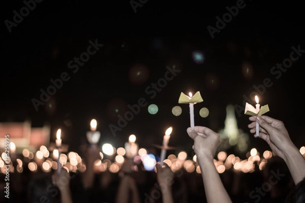 Obraz Blurred image for background of hand with candle memorable for King Bhumibol Adulyadej of thailand