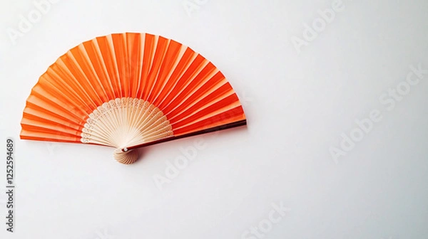 Fototapeta orange folding hand fan on white background  - asian culture and decoration - summer and warm weather symbol -  minimalist design  - stock photo
