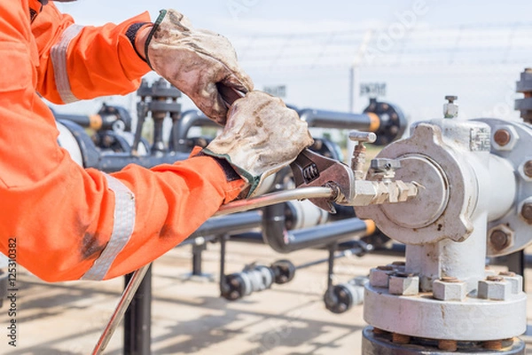 Fototapeta Close-up image of human hand fixing and stop leak stainless tube by wrench in oil and gas process