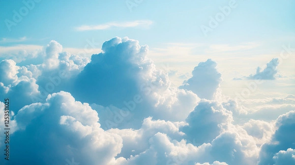 Fototapeta A serene sky filled with fluffy white clouds against a soft blue backdrop, creating a peaceful and uplifting atmosphere.