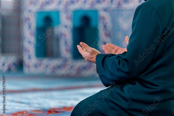 Fototapeta A captivating image of an imam praying after praying and reciting the Quran in a tranquil mosque, capturing the essence of faith and devotion.