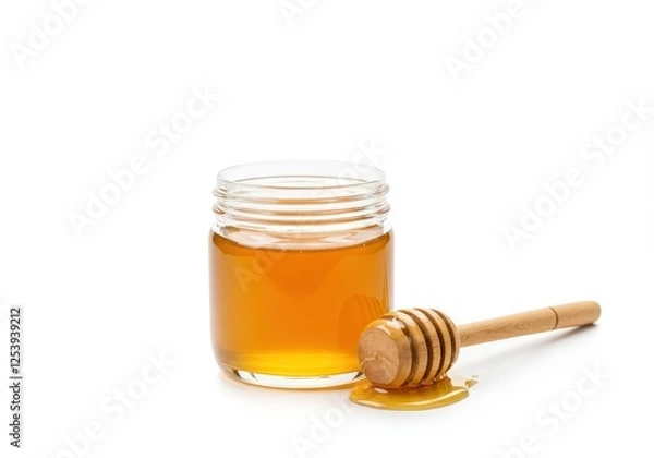 Fototapeta A small glass jar filled with golden honey accompanied by a wooden honey dripper with dripping honey isolated on white background