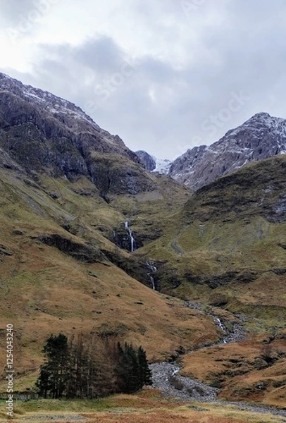Fototapeta heart of glencoe in the scottish highlands, idyllic waterfall running down a majestic mountain painted in autumn colors, charming atmosphere of scotlands countryside