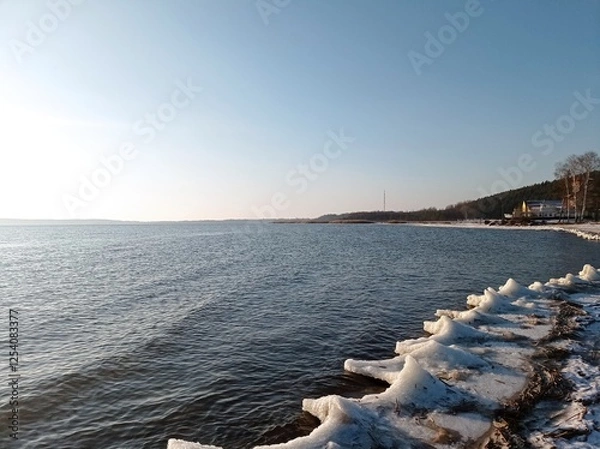 Fototapeta Serene Winter Seascape with Icy Shoreline and Calm Blue Waters, Capturing the Tranquility of a Frozen Beach at Sunset