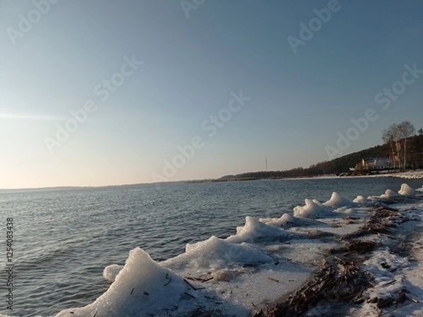 Fototapeta Serene Winter Seascape with Icy Shoreline and Calm Blue Waters, Capturing the Tranquility of a Frozen Beach at Sunset
