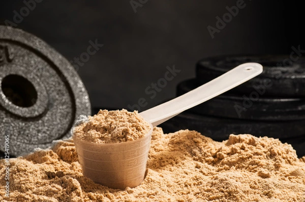 Fototapeta Scoop of whey protein on black background. Chocolate flawour