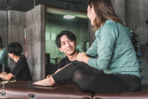 Obraz 柔道整復師に足首の捻挫・ケガのリハビリを相談をするアジア人女性
