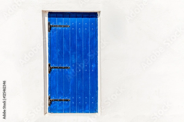 Fototapeta white wall with blue door