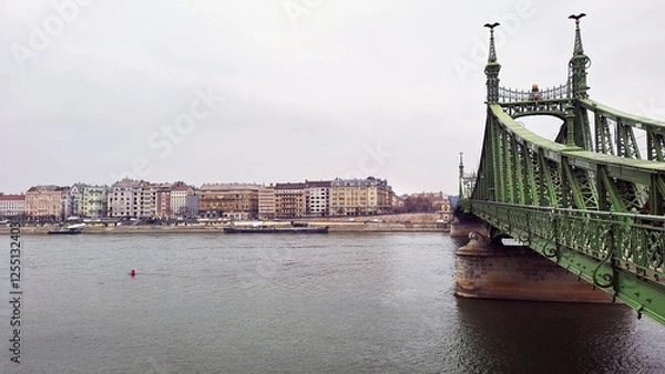 Obraz Southern end riverside of the Pest City Centre with the Liberty Bridge on the right that connects Buda and Pest. View of Buda along the Danube River shore at a winter sunset, Budapest, Hungary, Europe