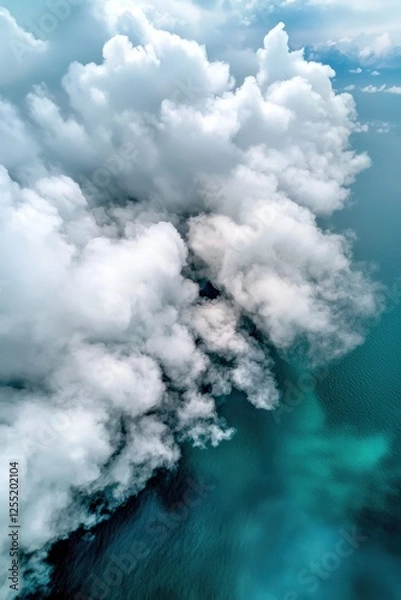 Fototapeta Puffy white clouds drifting over a turquoise ocean, casting shadows on the water,