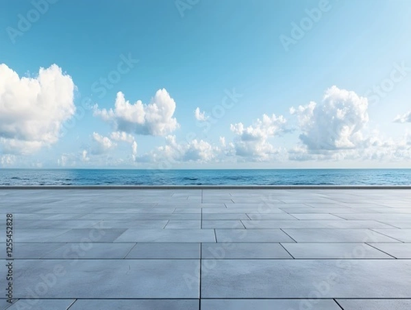 Fototapeta Serene Ocean View from a Modern Stone Terrace Under a Bright Blue Sky with Fluffy Clouds