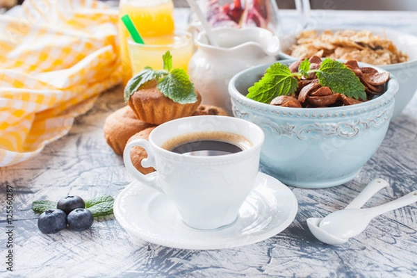 Fototapeta coffee, flakes and cakes on a table, selective focus