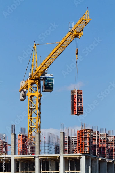 Obraz Yellow construction tower crane and house under construction