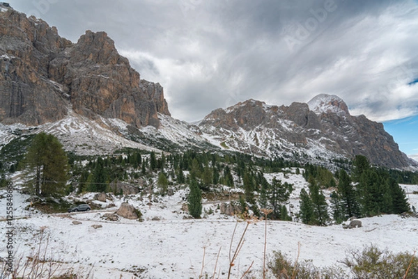 Fototapeta Snow-covered alpine meadows and towering mountains under a dynamic sky. A perfect scene showcasing the raw beauty of winter in the Dolomites.