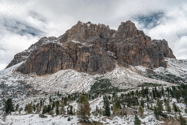 Fototapeta Snow-covered alpine meadows and towering mountains under a dynamic sky. A perfect scene showcasing the raw beauty of winter in the Dolomites.