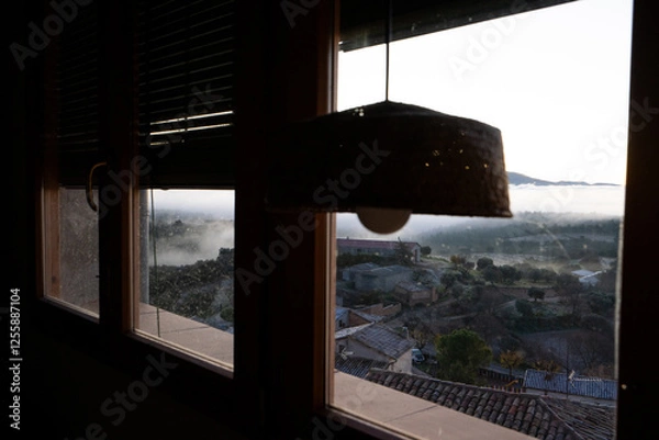 Fototapeta window with rustic chamber, foggy landscape and winter cold through the glass.