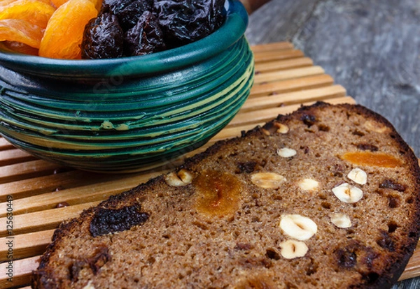 Fototapeta Sliced rye bread with prunes, dried apricots and hazelnut on old rustic table