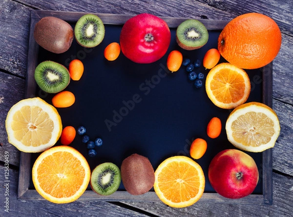 Fototapeta Fresh fruits oranges, kiwi, lemons, apples arranged in a group, natural still life for healthy food. Top view. Empty space for text. Colors toning