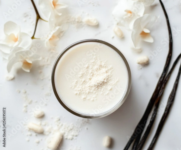 Fototapeta top view of A white nutritional shake product surrounded by vanilla. Clean and modern setup with natural lighting emphasizing the diverse flavor options